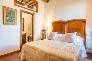a bedroom with a large wooden bed with white pillows at La Corte Medicea in Montepulciano