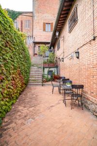 a patio with tables and chairs next to a brick building at La Corte Medicea in Montepulciano