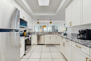 a large kitchen with white cabinets and appliances at Navarre Beach Regency 203 in Navarre