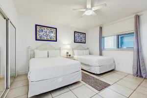 a bedroom with two beds and a ceiling fan at Navarre Beach Regency 203 in Navarre