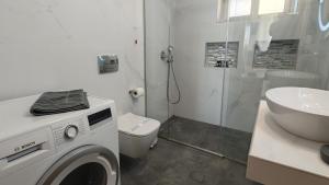 a bathroom with a washing machine and a sink at Tago Houses in Elafonisos +42 photos