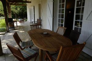 a wooden table and chairs on a patio at Les forts in Leigné-les-Bois
