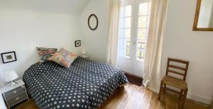 a bedroom with a bed and a chair and a window at Les forts in Leigné-les-Bois