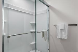 a glass shower with white towels in a bathroom at StudioRes by Marriott Newnan in Newnan +34 photos