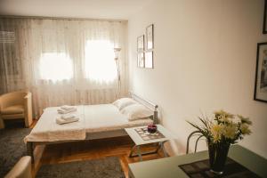 um quarto com uma cama, uma mesa e uma janela em Apartment Stela em Belgrado