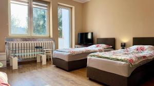 a room with two beds and a tv in it at Noclegi Witoszyn - Akacjowa 2 in Witoszyn Dolny