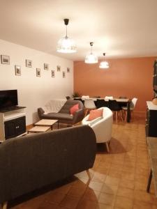 a living room with a couch and a dining room at Le clos des vaches in Usson-du-Poitou