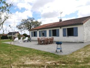 a house with a table and chairs in front of it at Le clos des vaches in Usson-du-Poitou +9 photos