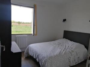 a bedroom with a bed and a window at Le clos des vaches in Usson-du-Poitou