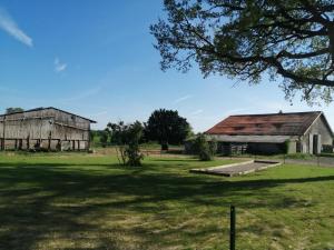 an old barn in a field with a tree at Le clos des vaches in Usson-du-Poitou