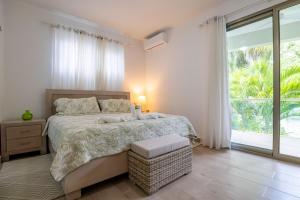 a bedroom with a bed and a large window at Pro Cab Apartment - Washer - BBQ in Cabarete