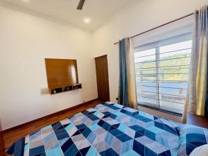 a bedroom with a checkered bed in front of a window at Mananjay Natures Retreat in Jāmb