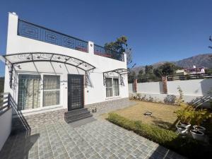 a white house with a door and a yard at Mananjay Natures Retreat in Jāmb
