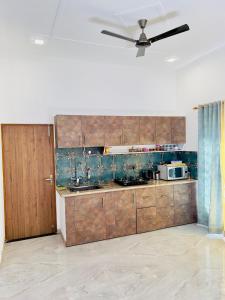 a kitchen with wooden cabinets and a ceiling fan at Mananjay Natures Retreat in Jāmb