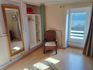a room with a chair and a mirror and a window at Kerioret Izella in Kerlaz