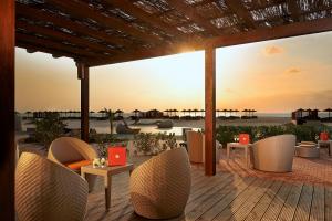 a patio with chairs and tables and a view of the beach at SOL by Meliá Dunas Family Fun in Santa Maria