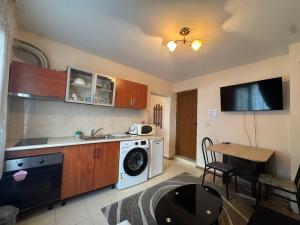 a kitchen with a washing machine and a table at Berta Gardens 1 in Sandanski