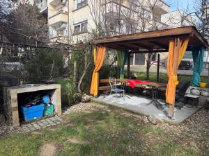 a picnic shelter with a table and a fireplace at Berta Gardens 1 in Sandanski +1 photo