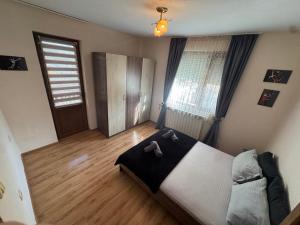 a bedroom with a large bed and wooden floors at Berta Gardens 1 in Sandanski