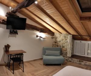 a room with a tv and a chair and a table at Casa rural Abatetxe in Elgóibar