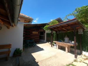 a patio with a bench and a wooden pergola at Chergata Guest House in Zheglitsa