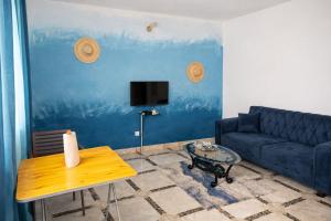 a living room with a blue couch and a table at Résidence Gnimakel in Abidjan