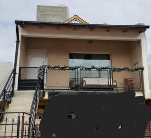 a house with a balcony with a couch on it at Los del Sur cabañas in Comodoro Rivadavia