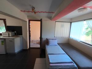 a room with two beds and a kitchen with a window at Chergata Guest House in Zheglitsa