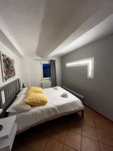 a bedroom with a bed with a yellow pillow at Casa San Pietro centro storico in Castagnole Lanze