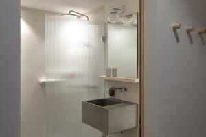 a bathroom with a sink and a mirror at Hôtel Bodenhaus in Splügen +44 photos