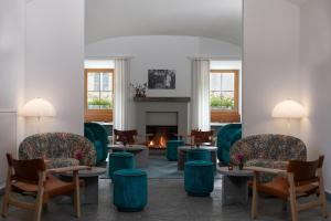 a waiting room with chairs and a fireplace at Hôtel Bodenhaus in Splügen