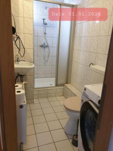 a bathroom with a shower toilet and a washing machine at Monteurwohnung bei Nina in Zeitz