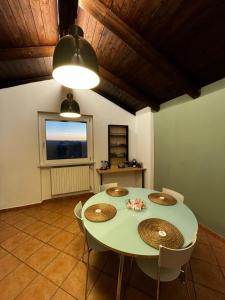 a dining room with a table and chairs and a window at Casa San Pietro centro storico in Castagnole Lanze +21 photos