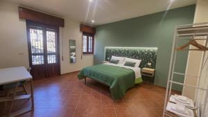 a bedroom with a bed with a green blanket at Oasi Perla Del Mare Rooms in Aci Castello