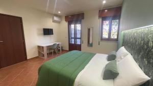 a bedroom with a large bed and a desk in it at Oasi Perla Del Mare Rooms in Aci Castello