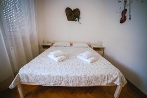 a bedroom with a bed with two towels on it at Viktorija Apartment in Belgrade