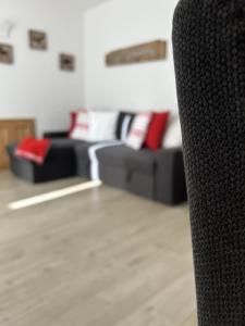 a living room with black couches and red pillows at Bormio suite apartment, terme e sci a 5 min. di auto in Valdisotto