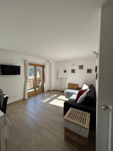 a living room with a couch and a television at Bormio suite apartment, terme e sci a 5 min. di auto in Valdisotto
