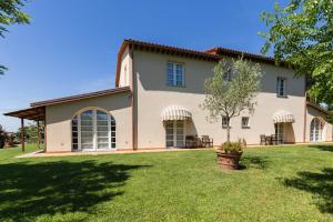 an exterior view of a house with a yard at La Matassina Tuscany in Castellina Marittima