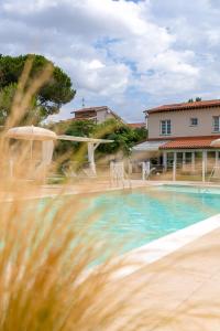 a house with a swimming pool in front of a house at La Matassina Tuscany in Castellina Marittima