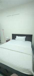 a bedroom with a white bed with a white pillow at Hangang HOTEL 한강호텔 in Jāmb