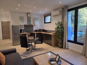 a large kitchen and living room with a table and chairs at HPC Suites - Cassis Centre - Parking Securisé et Piscine Chauffée in Cassis +24 photos