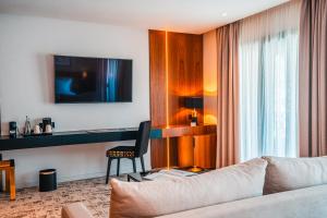 a living room with a couch and a tv at BRĂAT Hôtel in Rabat