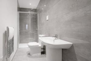 a bathroom with a toilet and a sink and a shower at Roomspace Serviced Apartments - Nouvelle House in Sutton +7 photos
