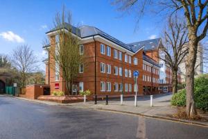 a large red brick building on the side of a street at Roomspace Serviced Apartments - Nouvelle House in Sutton