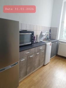 a small kitchen with a sink and a microwave at Monteurwohnung bei Nina in Zeitz
