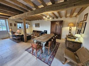 a dining room with a wooden table and chairs at Gîte de la petite touche in Seligny