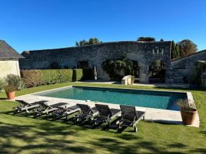 a group of chairs sitting next to a swimming pool at Gîte de la petite touche in Seligny