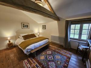 a bedroom with a large bed and a rug at Gîte de la petite touche in Seligny +29 photos