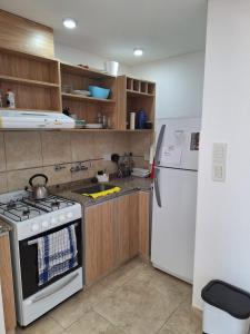 a kitchen with a stove and a refrigerator at Artigas 505 dpto 2 in Colón +7 photos